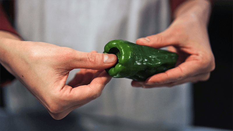 ピーマンのヘタの部分を親指で押して、種ごと中に押し込む。