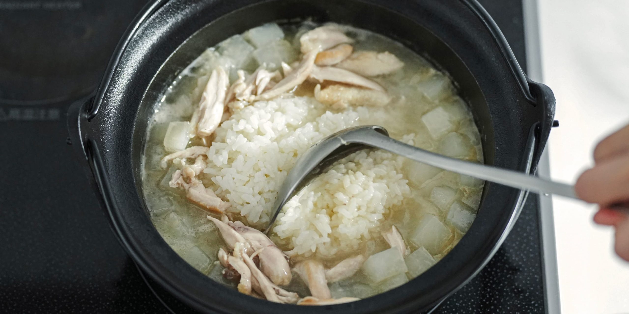 再び火をつけて、ごはん、残りの塩、ほぐした手羽中、すりごまを入れて軽く混ぜる